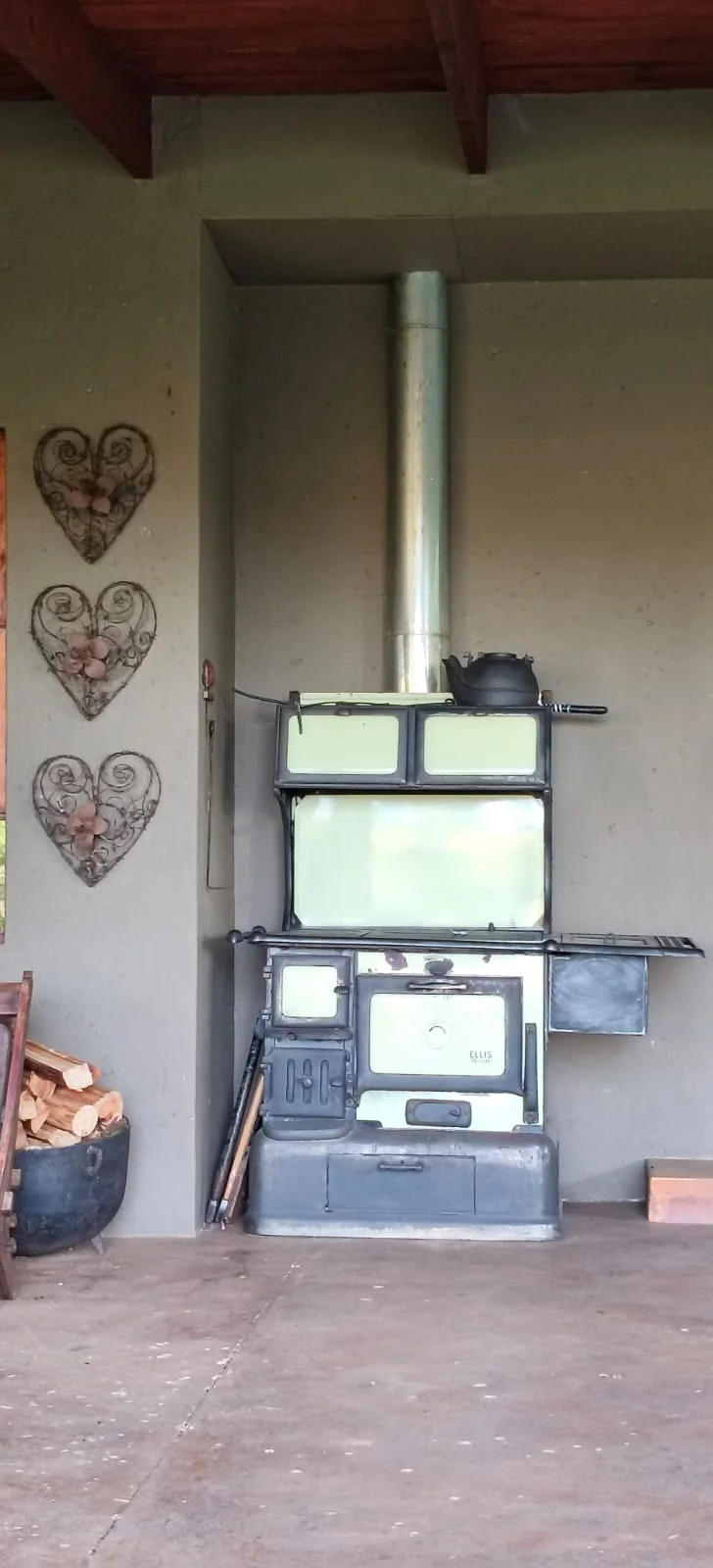 A cast-iron wood stove against the wall of a farm verandah.